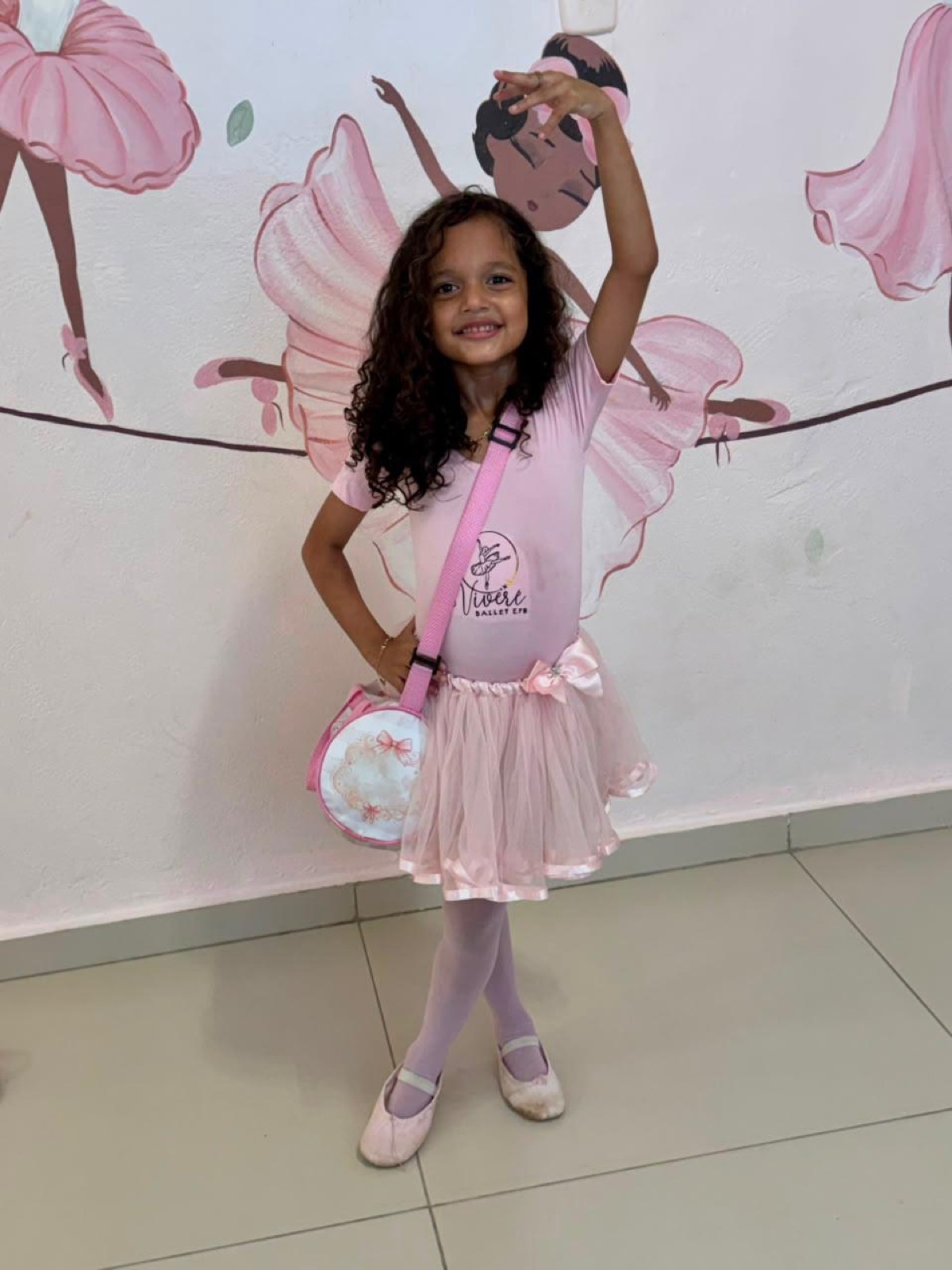 Bailarina do Viveré Ballet posando em frente ao mural