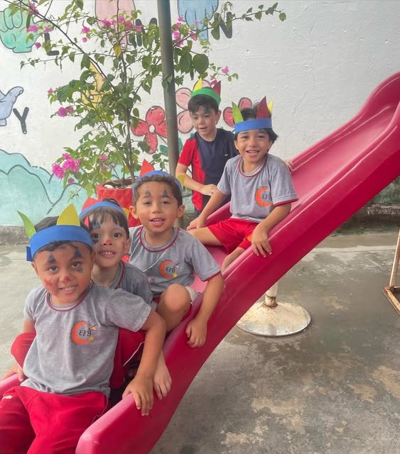Crianças brincando no escorregador da escola